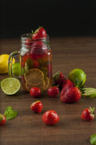 water in a glass jar with strawberries and lemon slices