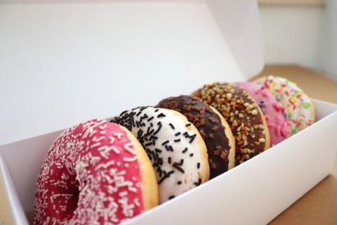 an assortment of decorated donuts placed in a carton