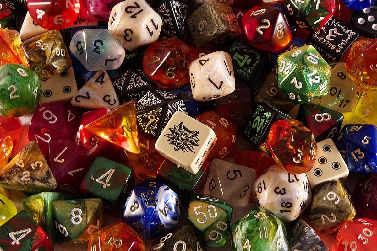 various colorful D N D dice are scattered on a table 